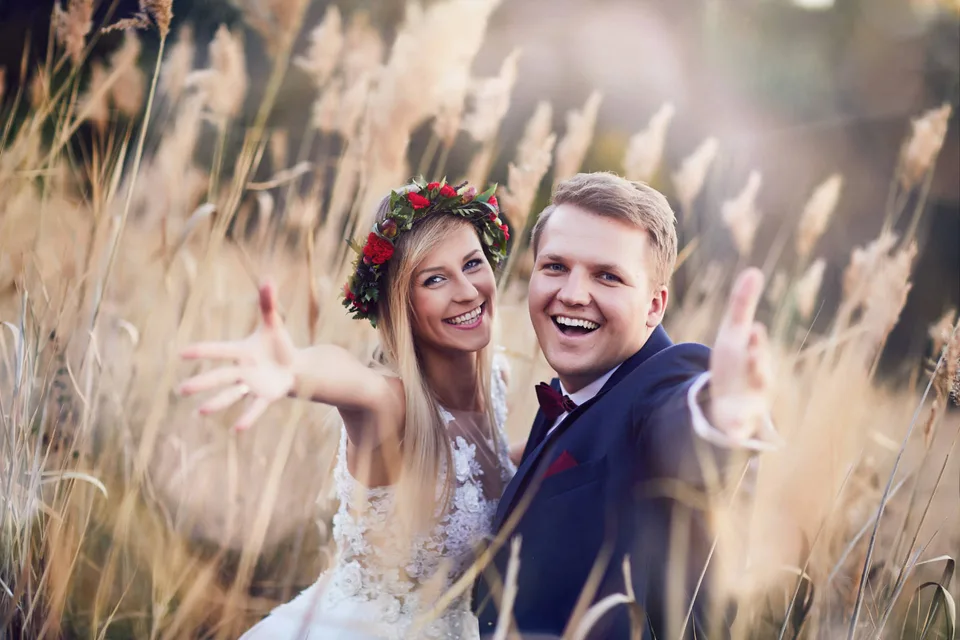 Uśmiechnięta para młoda podczas pleneru wśród traw